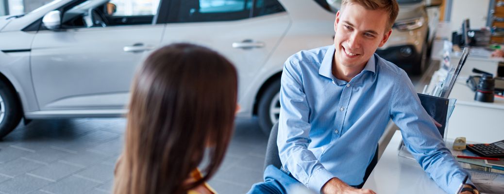 a man and a woman talking at a dealership