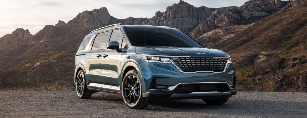 2024 Kia Carnival Blue parked near mountains