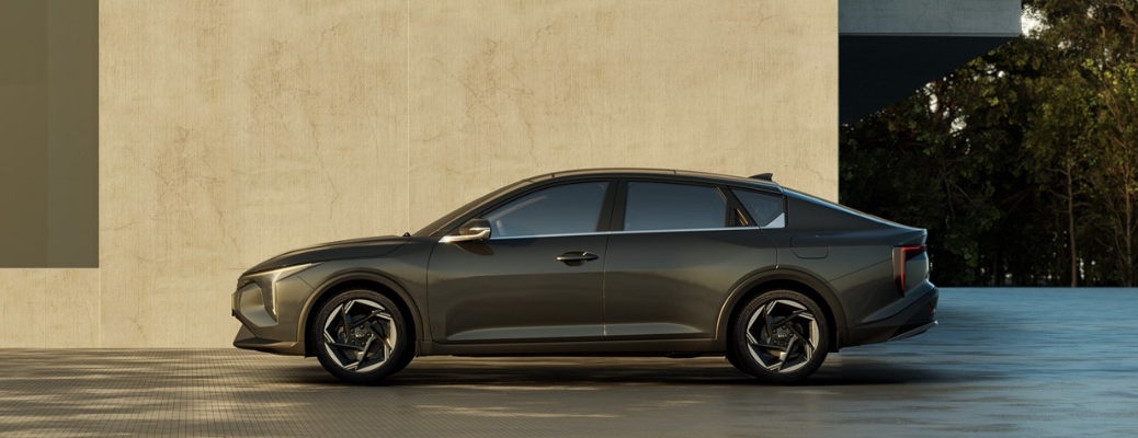 Side view of the 2025 Kia K4 parked in front of a building
