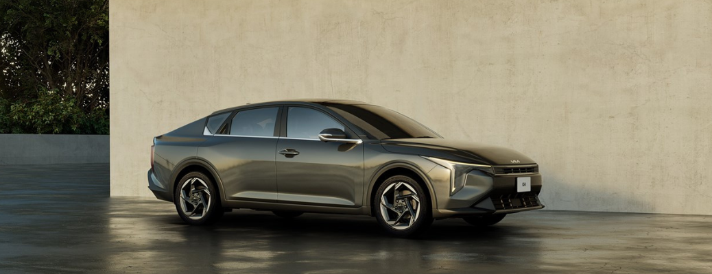 Side view of the 2025 Kia K4 parked in front of a wall