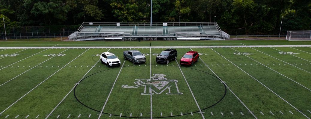 4 Kia vehicles parked at the St. Vincent-St. Mary High School