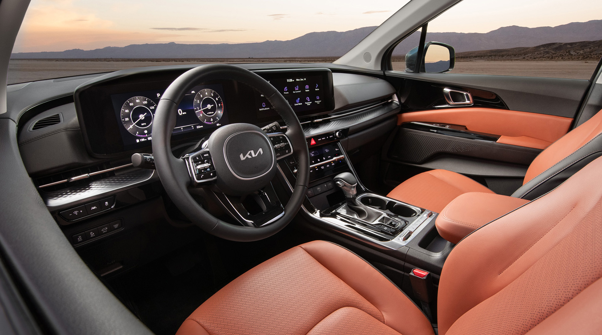 Interior of a Kia SUV with modern dashboard displays and orange leather seats